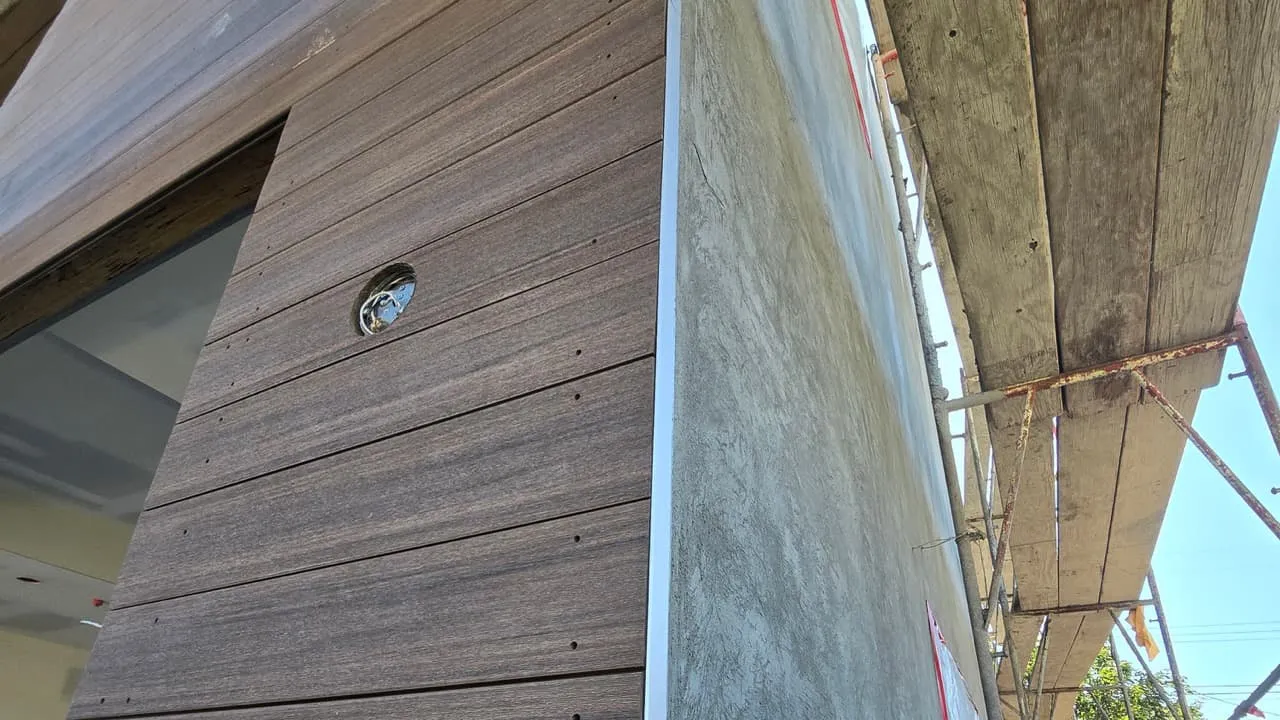 On-site siding mockup comparing a standard boxy corner cap against the approved flush vertical edge-trim transition on horizontal composite boards