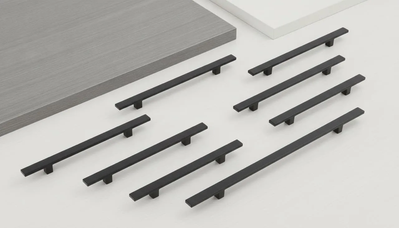 Matte black cabinet pull swatches in 3-inch and 6-inch sizes arranged over finished white and grey cabinet door samples